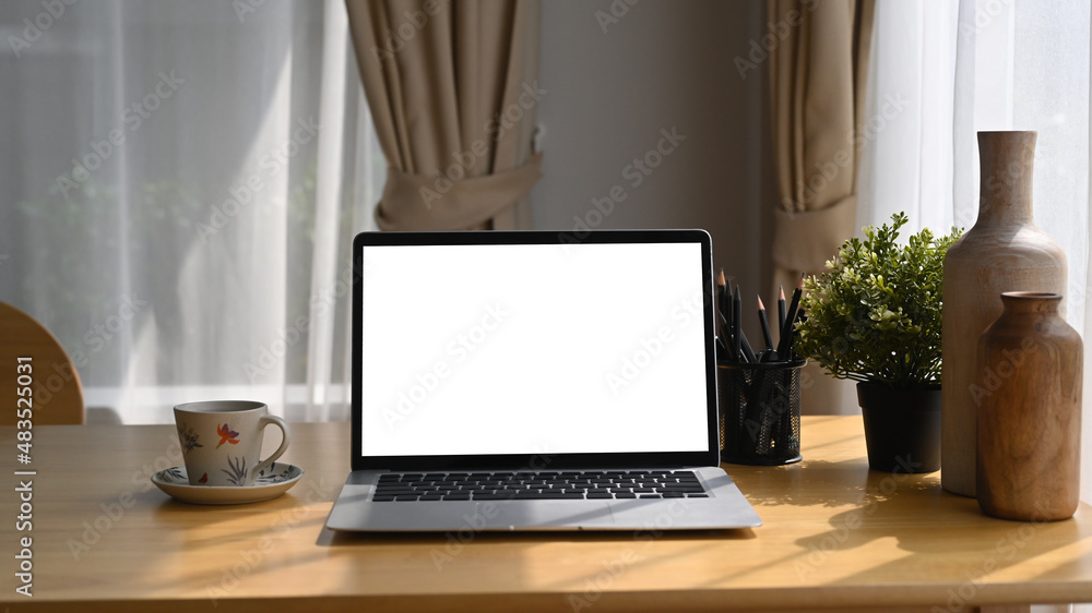 Computer laptop with white blank screen, coffee cup an houseplant on wooden table. Computer laptop with white blank screen, coffee cup an houseplant on wooden table.