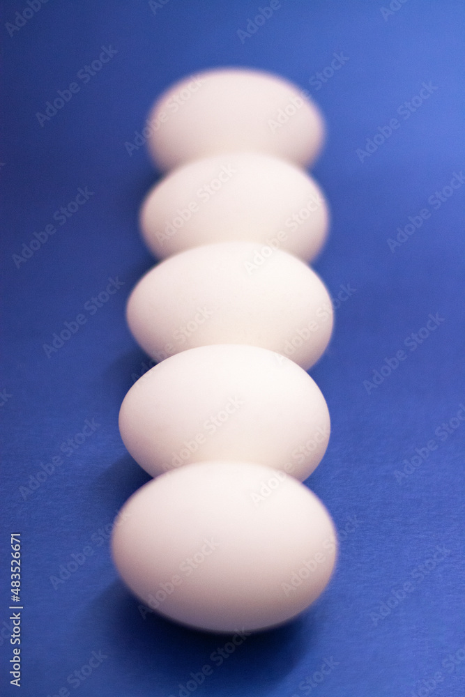 Five white raw eggs lie on the table. Vertical photo, large eggs. Preparing for Easter. Easter Ingredients Five white raw eggs lie on the table. Vertical photo, large eggs. Preparing for Easter. Easter Ingredients