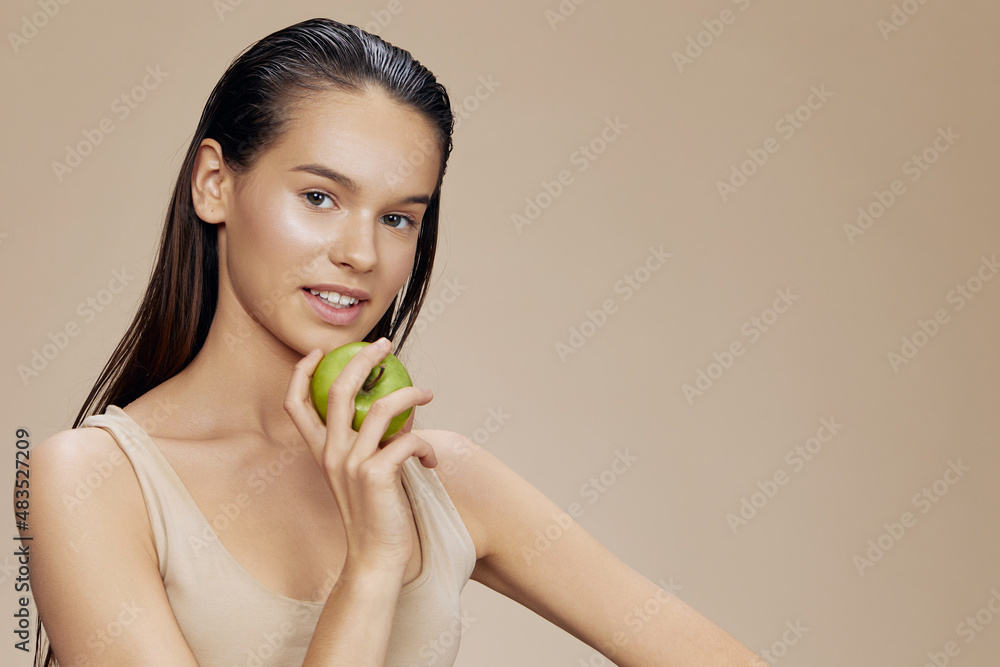 portrait woman green apple near face health beige background