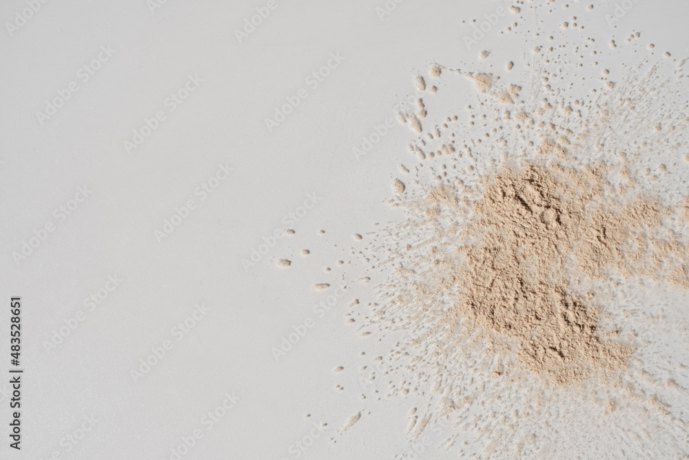 Close up of neutral beige make up cosmetic powder sprinkle on white background. Aesthetic minimalist beauty branding, merchandise concept