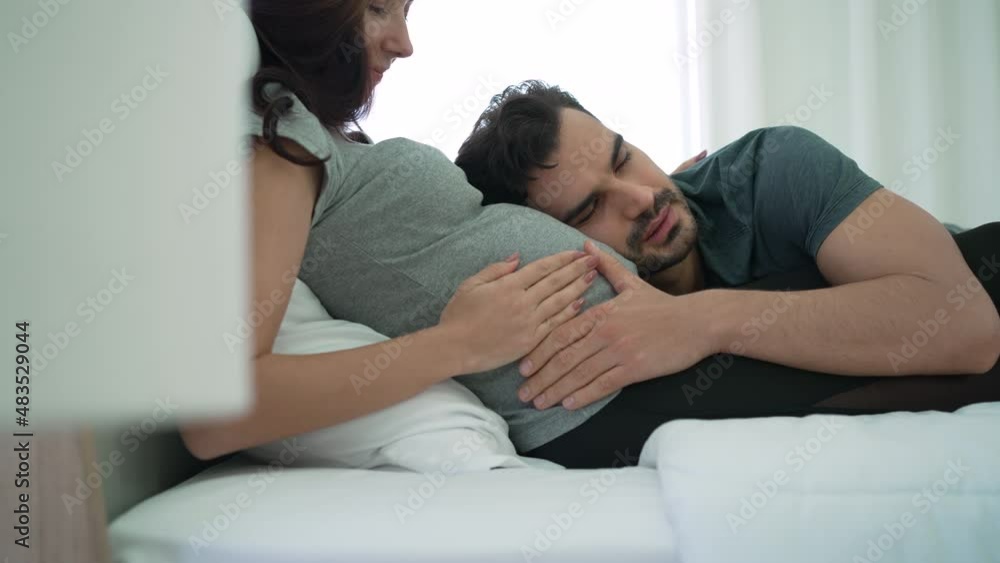 Caucasian Pregnant Couple Lying Together in Bed Caucasian Pregnant Couple Lying Together in Bed