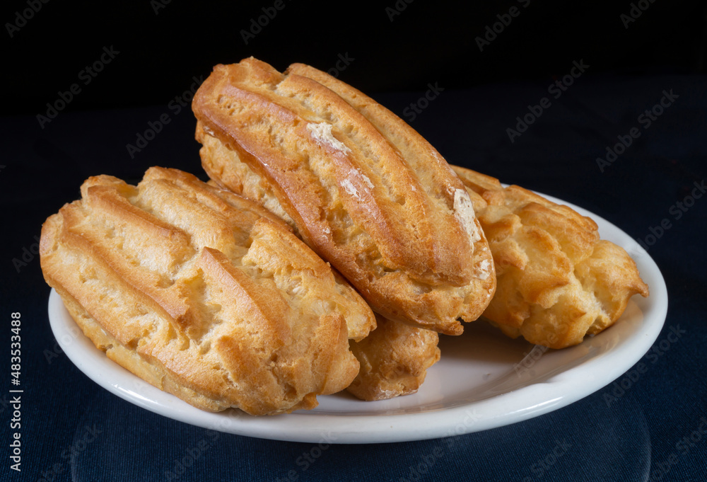 Sweet pastries in a white plate on a black background Sweet pastries in a white plate on a black background