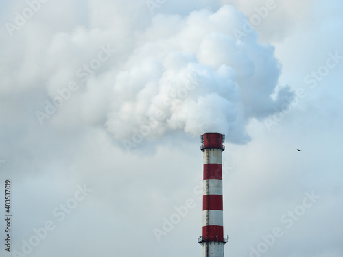Environmental pollution. The tall chimney releases smoke and steam.