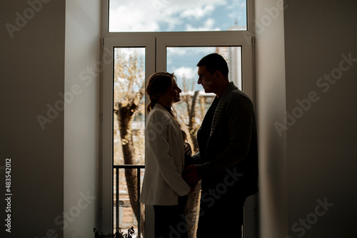 Beautiful pregnant woman and her handsome husband are hugging and smiling while spending time together © Владислав Легір