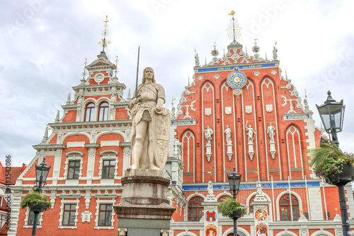 The House of the Blackheads and the statue of Roland in the center of the old town of Riga - colorful postcard of the capital of Latvia with a cloudy background