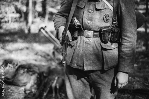 Re-enactor Dressed As World War II German Wehrmacht Soldier Holds Soviet Rifle. Photo In Black And White Colors. Military German Soldier In Uniform Of WWII Times.