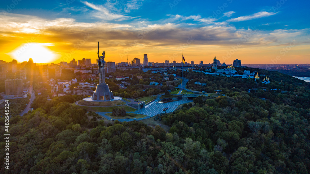 Aerial view to the Motherland statue in the Kiev while  summer sunset. The well-known landmarks in Kyiv. Historical monument of Soviet union. Beautiful city Kiev while sunset.