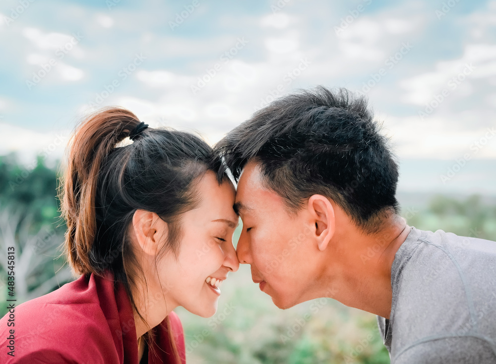 Side view of young couple face touching and smile, concept of couple relationship and valentine Side view of young couple face touching and smile, concept of couple relationship and valentine