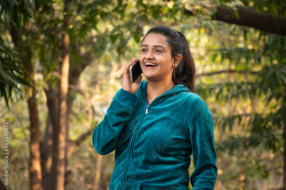 Portraits of young woman doing exercise in park and taking on phone Portraits of young woman doing exercise in park and taking on phone