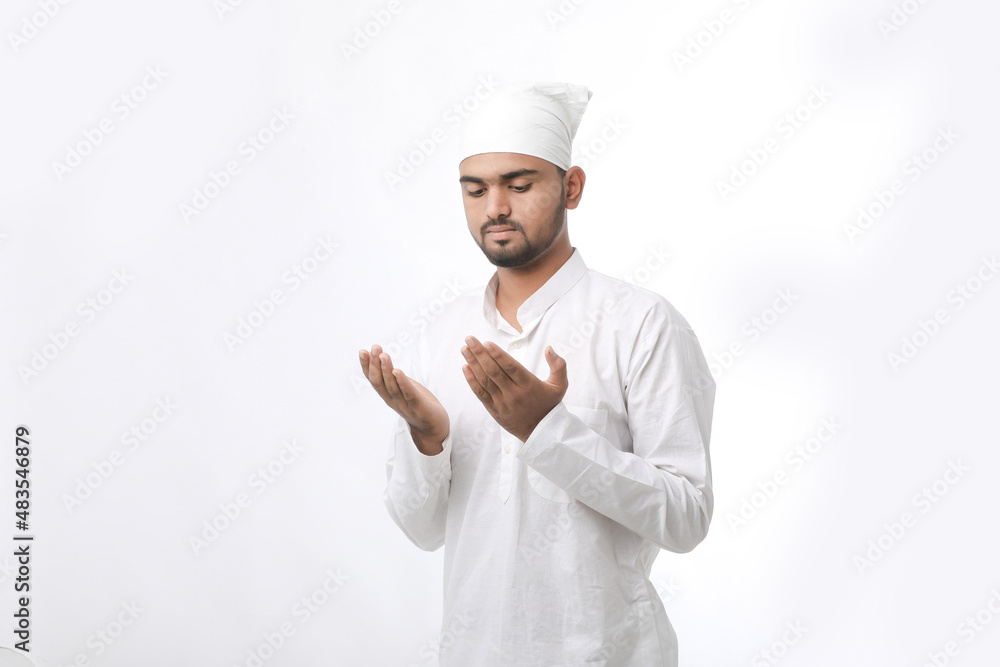 Indian muslim religious man praying on white background. Indian muslim religious man praying on white background.