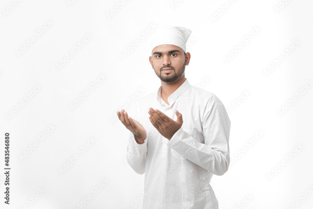 Indian muslim religious man praying on white background.