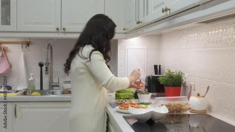 Woman cooking festive dinner in the kitchen making canape topped with savoury food. Appetizer canape with red caviar. High quality 4k footage Woman cooking festive dinner in the kitchen making canape topped with savoury food. Appetizer canape with red caviar. High quality 4k footage