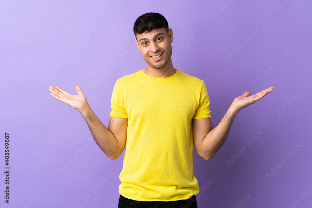 Young Colombian man isolated on purple background with shocked facial expression Young Colombian man isolated on purple background with shocked facial expression