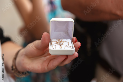 Wallpaper Mural an orthodox cross for the rite of christening a child in a white box for jewelry a woman with a red manicure holds in her hands Torontodigital.ca
