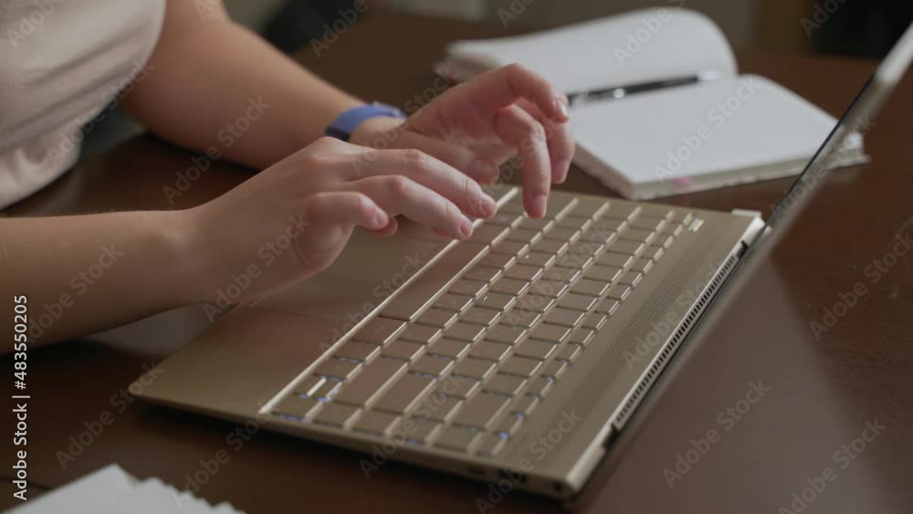 Female hands are typing text on laptop keyboard. Fingers quickly press the keys on the keyboard. There is notebook next to it. Personal computer, remote work at home, business, study, messaging, chat Female hands are typing text on laptop keyboard. Fingers quickly press the keys on the keyboard. There is notebook next to it. Personal computer, remote work at home, business, study, messaging, chat