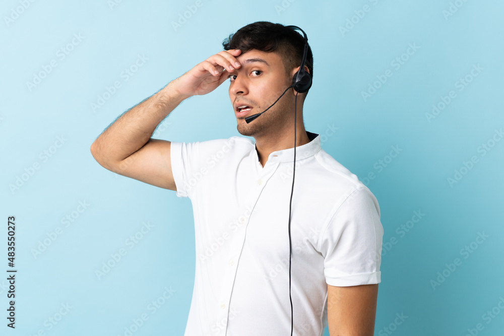 Telemarketer Colombian man working with a headset over isolated background doing surprise gesture while looking to the side Telemarketer Colombian man working with a headset over isolated background doing surprise gesture while looking to the side