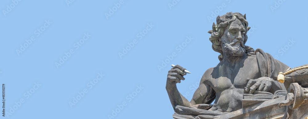 Banner with old statute of poet or writer with book, Bible, writing something at historical center of Dresden, Germany, at blue sky solid background with copy space.