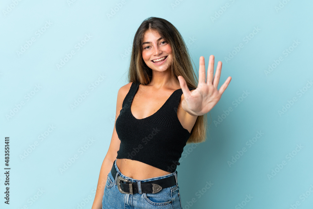 Young caucasian woman isolated on blue background counting five with fingers Young caucasian woman isolated on blue background counting five with fingers