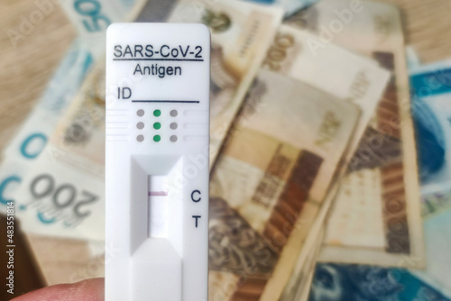 Coronavirus rapid antigen test with polish PLN banknotes. Corona virus SARS-Cov-2 fast negative test. test cassette on several euro banknotes background