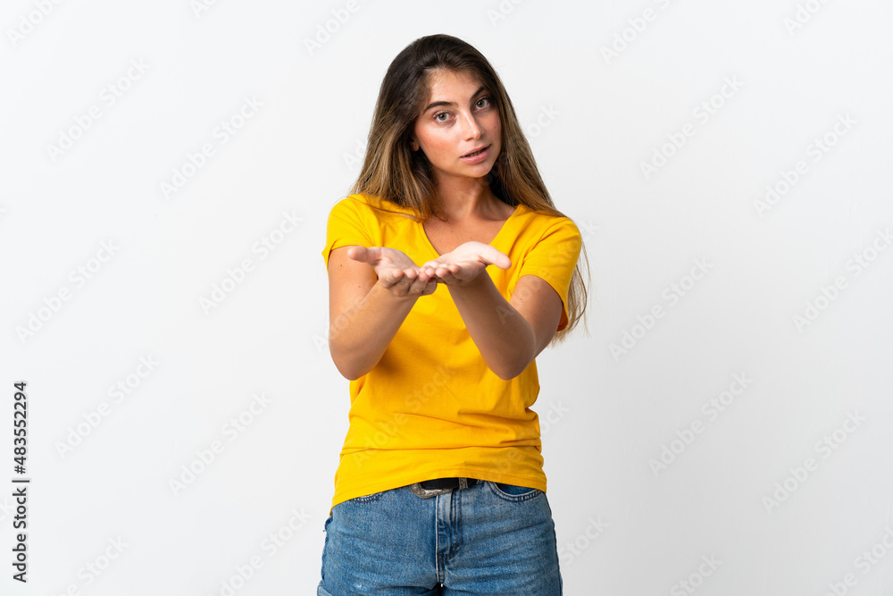 Young caucasian woman isolated on white background holding copyspace imaginary on the palm to insert an ad Young caucasian woman isolated on white background holding copyspace imaginary on the palm to insert an ad