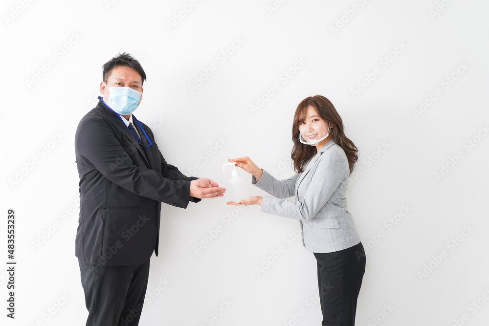 アルコール消毒をお願いするビジネスパーソン