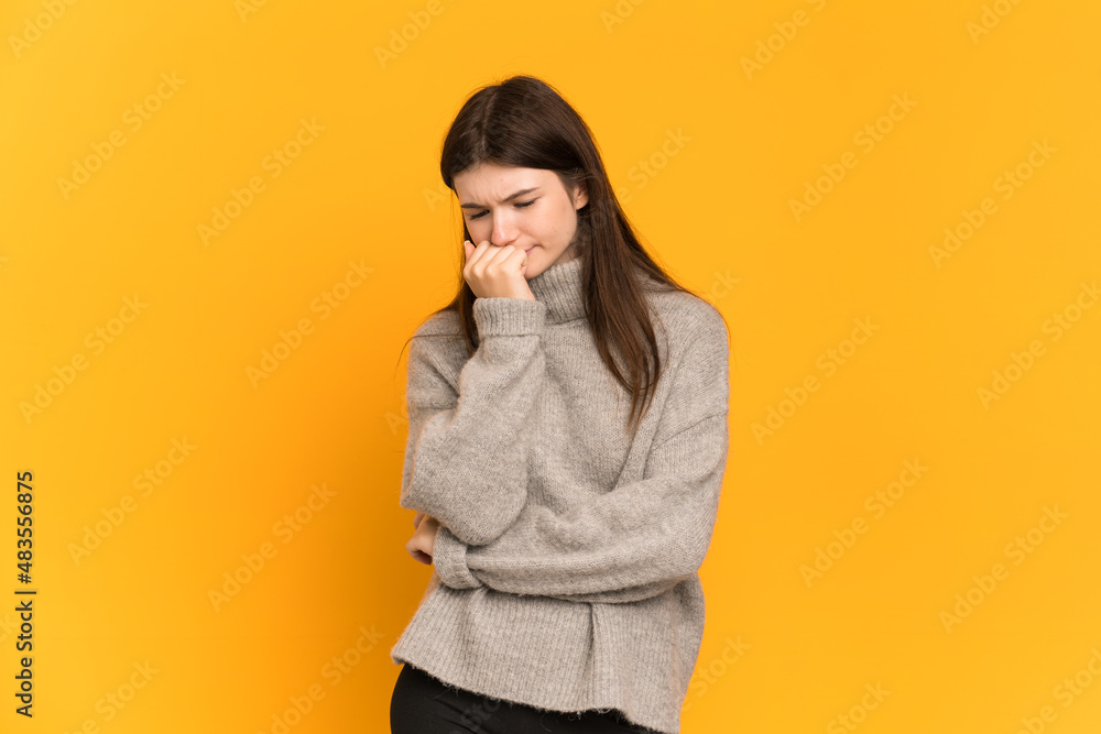 Fototapeta premium Young Ukrainian girl isolated on yellow background having doubts