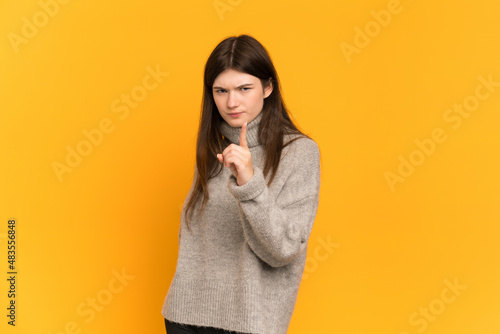 Young Ukrainian girl isolated on yellow background frustrated and pointing to the front © luismolinero