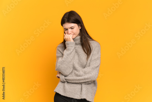 Young Ukrainian girl isolated on yellow background having doubts © luismolinero