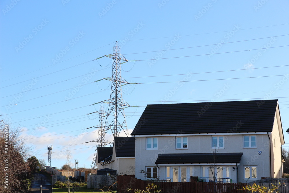 Electric pylon and g5 mast behind a house Electric pylon and g5 mast behind a house