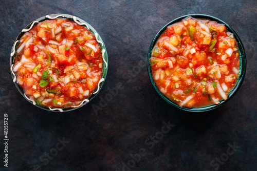 Bowl of mexican salsa sauce on a dark background. Traditional Latin American salsa sauce. Top view. Copy space