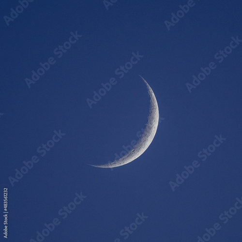 A waning crescent moon in a dark sky photo