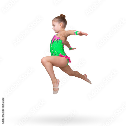 A six-year-old girl in the form of a rhythmic gymnast performs a jumping exercise "touching"