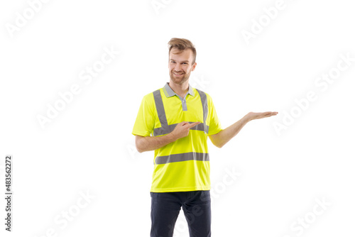 A middle-aged white man wearing a green uniform t-shirt standing over an isolated white background. He holds his hand up in the air, pointing at something. Worker and builder concept. © German