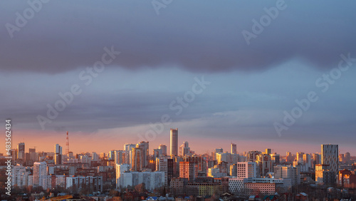 Dawn clouds over the metropolis of early sunset © kirillk