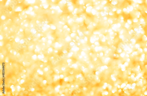 Blurred festive golden background. Bokeh background of yellow Christmas sparkles. Beautiful Christmas decoration of the interior of the house.