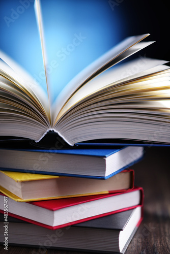Foto A composition with an open book lying on a stack of other books