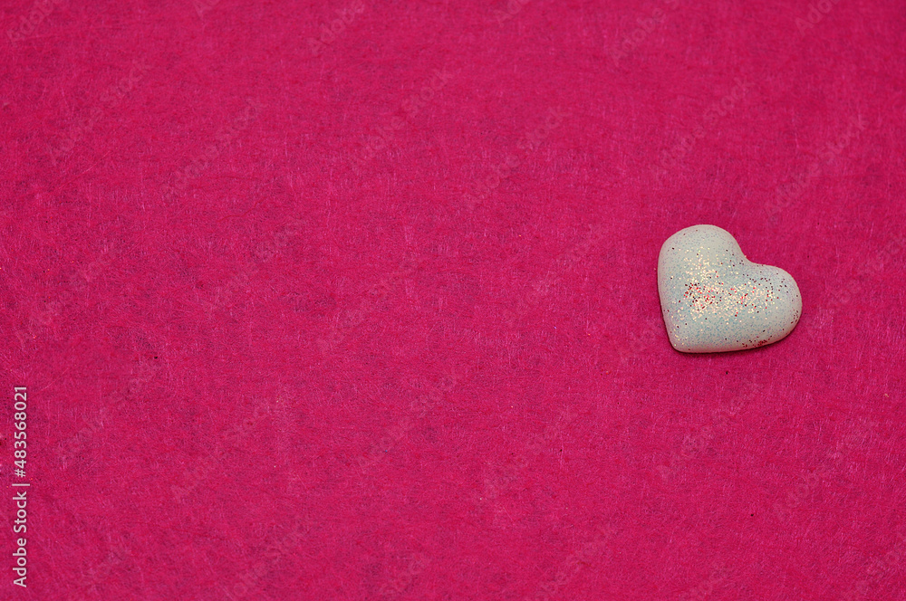Fototapeta premium A white heart isolated on a pink background