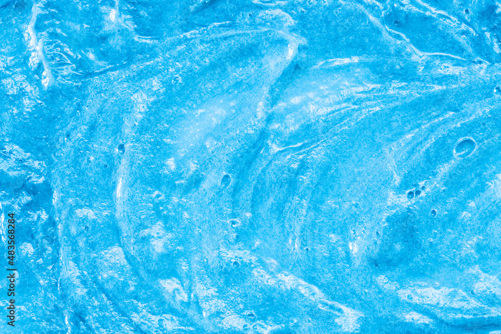 Obraz premium Blue cream texture. The surface of berry yogurt and a smoothie of whipped cream. Background texture of masks and scrubs for face and body. Pearlescent silver surface of blue foam.