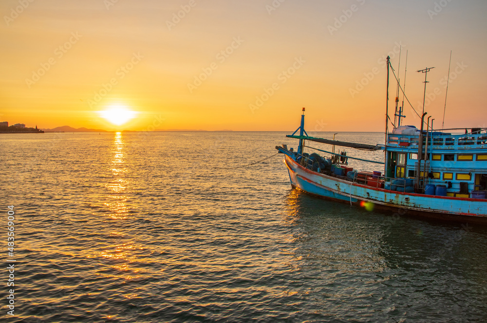 A fishing boat at a pier in the early evening during sunset time