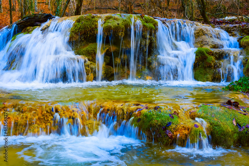 closeup small waterfall on mountain river rushing through the mountain canyon