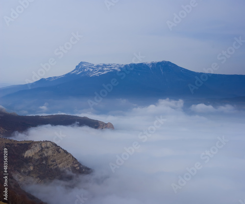 mountain valley slihouette in dense mist, natural background © Yuriy Kulik
