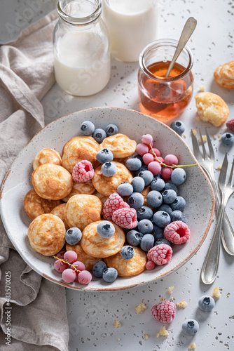 Dutch poffertjes with yoghurt and frozen berries.