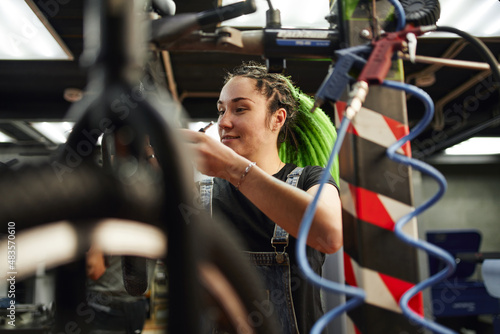 Female master smiling during repairing works in garage