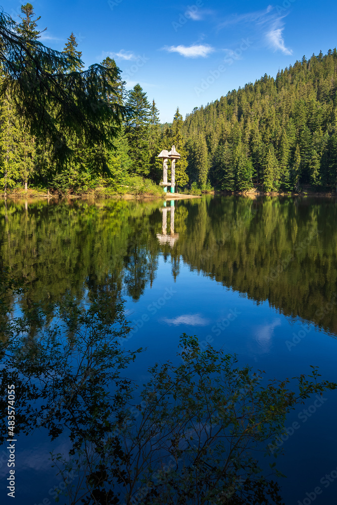Fototapeta premium landscape with lake in summer. reflection in the water. beautiful nature background of synevyr, ukraine. outdoor view on a sunny day with clouds on the sky