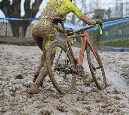 ciclocross cyclocross ciclista a pie con la bicicleta en la mano en una pista de barro competición  país vasco 4M0A4846-as22