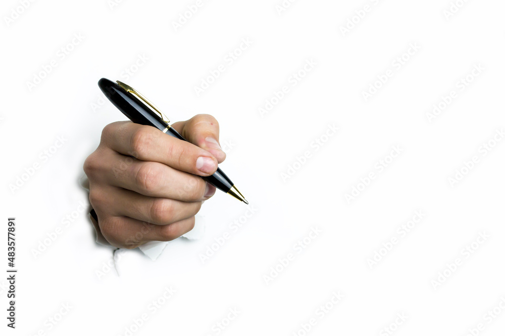The hand holds a black ballpoint pen on a white background. The hand holds a black ballpoint pen on a white background.