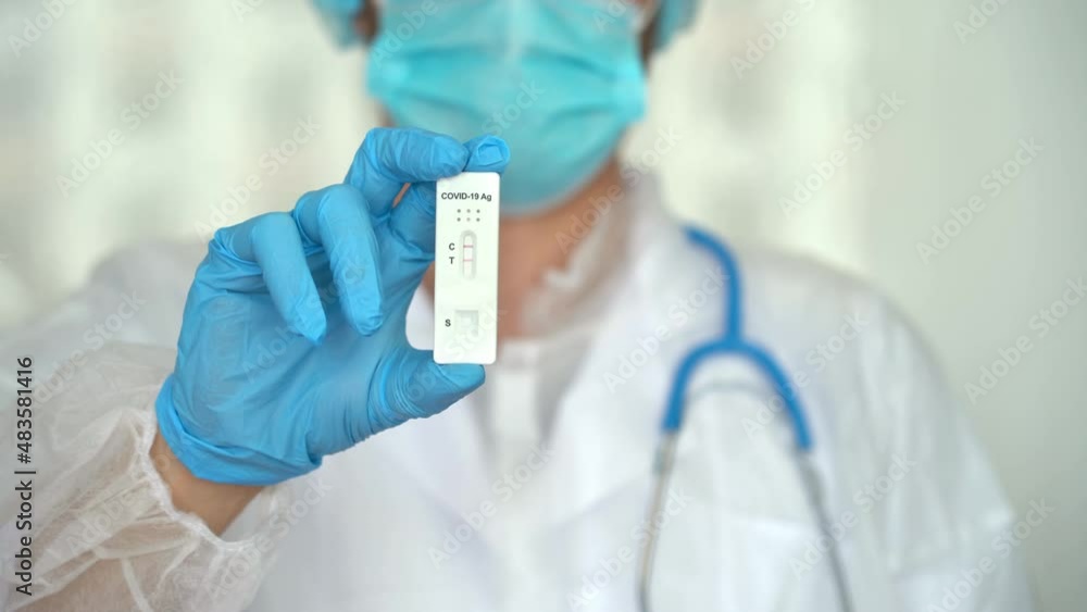 Hand in protective glove holds rapid antigen test for covid-19 in laboratory. Quick swab method to test Coronavirus SARS-CoV-2. PCR Hand in protective glove holds rapid antigen test for covid-19 in laboratory. Quick swab method to test Coronavirus SARS-CoV-2. PCR