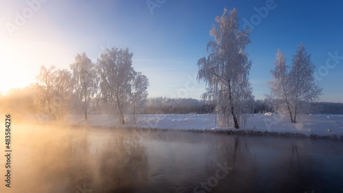 Snow-covered forest on the banks of the winter river, Russia, Ural January