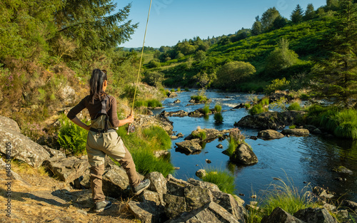 An asian female fly fisher women looking where to fish