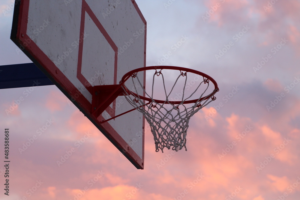 basketball hoop against sunset sky
